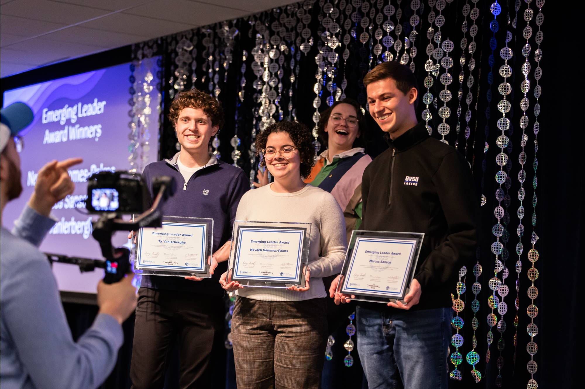 Students posing for the camera with their certificates